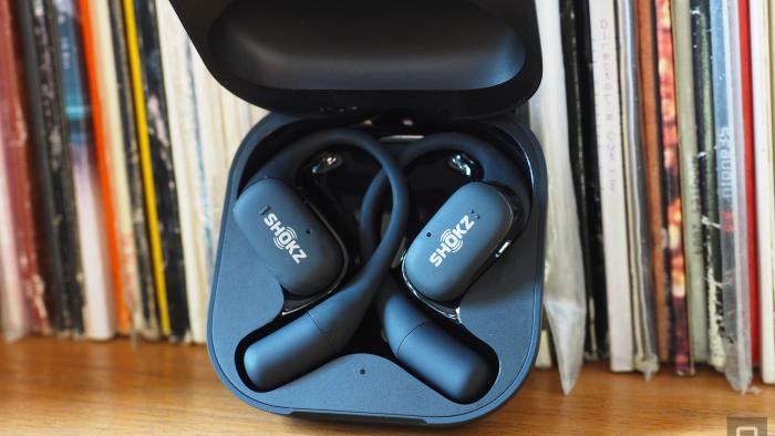 Close-up images of the Shokz OpenFit open-ear buds in grey with the charging case.