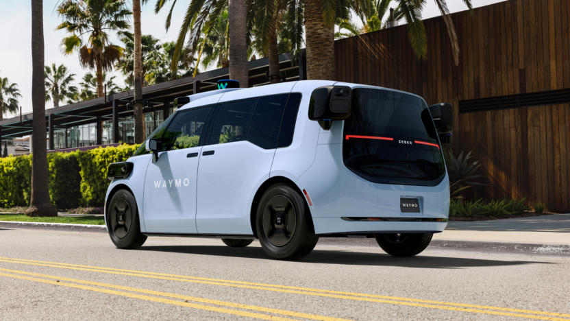 A Waymo automated SUV driving down a road. Sunny, palm trees.