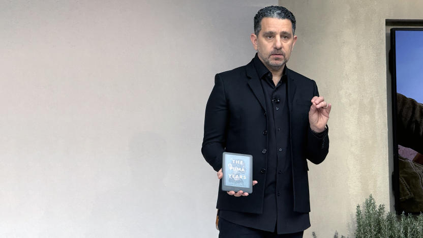 Panos Panay holding an Amazon Kindle Colorsoft onstage at a launch event.