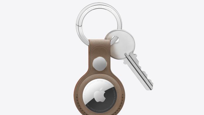 An Apple AirTag in a brown keyring caase with a silver key attached