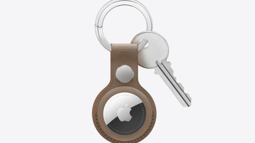 An Apple AirTag in a brown keyring caase with a silver key attached